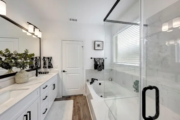 a bathroom with a tub sink and mirror