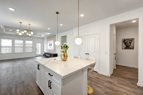 a kitchen with a sink a counter space and wooden floor