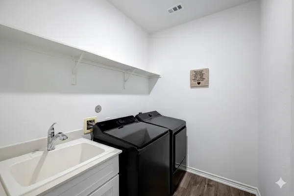a utility room with sink dryer and washer
