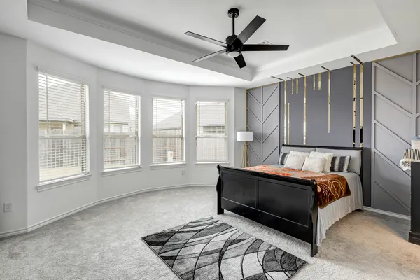 a spacious bedroom with a bed and a large window