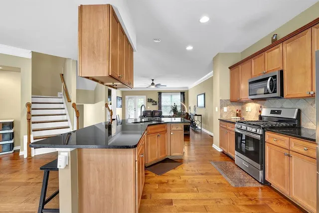 a kitchen with stainless steel appliances granite countertop a stove a sink and a microwave