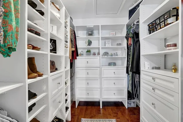 a view of walk in closet with clothes and shoes