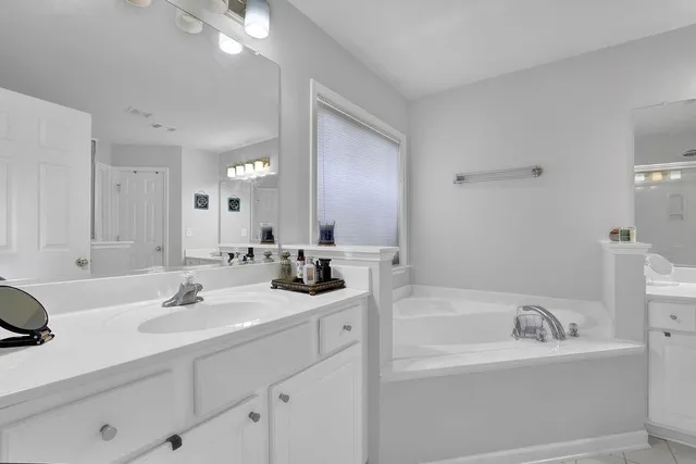 a bathroom with a bathtub sink a mirror and vanity