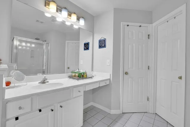 a bathroom with a sink vanity and a mirror