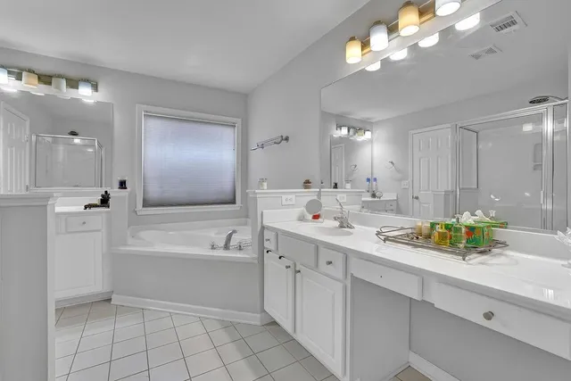 a bathroom with a sink a large mirror and a bathtub