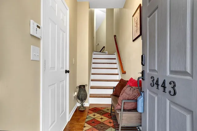 a view of a hallway with front door wooden floor and stairs