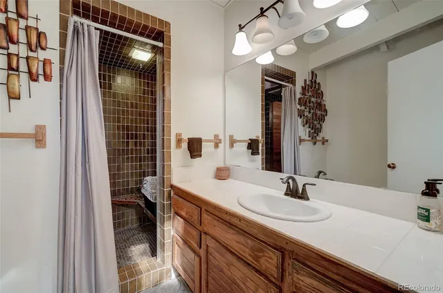 a bathroom with a sink a toilet a mirror and shower