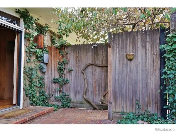 a view of a backyard with plants and wooden fence