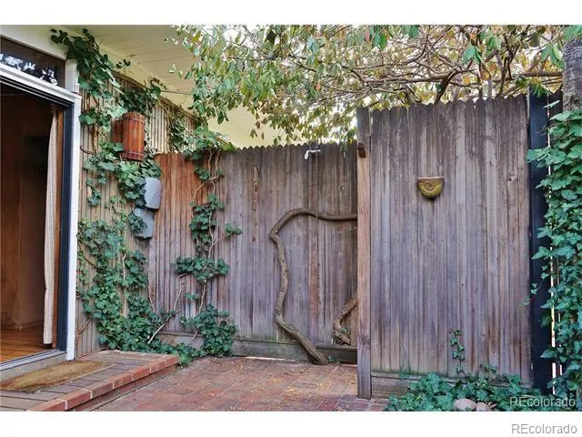 a view of a backyard with plants and wooden fence