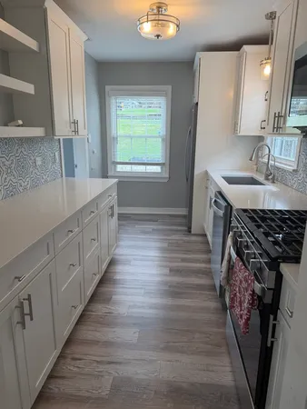 a kitchen with granite countertop a sink stove and cabinets