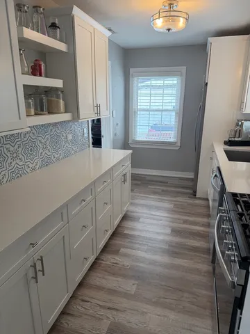 a kitchen with cabinets wooden floor and a fireplace