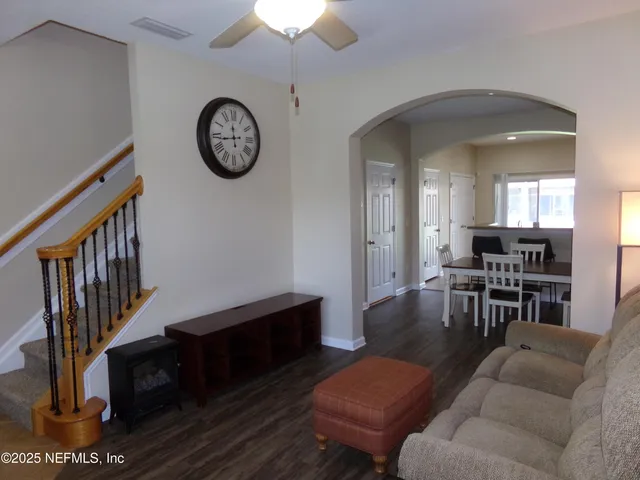 a living room with furniture a clock and a table