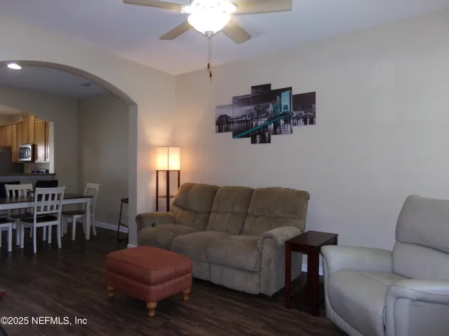 a living room with furniture wooden floor and a chandelier