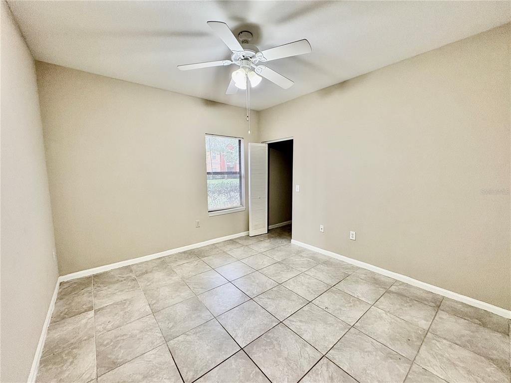 2199 Chianti Place, Unit 918 Palm Harbor, FL 34683 - Photo 11 of 23 an empty room with windows and ceiling fan