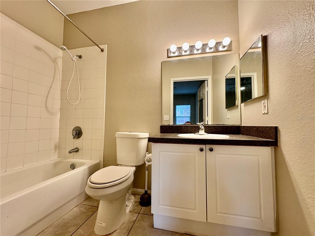 2199 Chianti Place, Unit 918 Palm Harbor, FL 34683 - Photo 12 of 23 a bathroom with a sink a toilet a mirror a vanity and bathtub