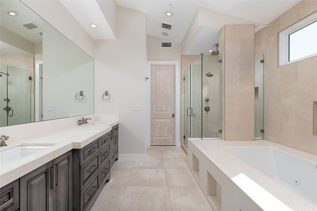 a spacious bathroom with a tub sink shower and mirror