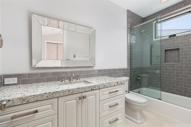 a bathroom with a granite countertop toilet sink and a bathtub