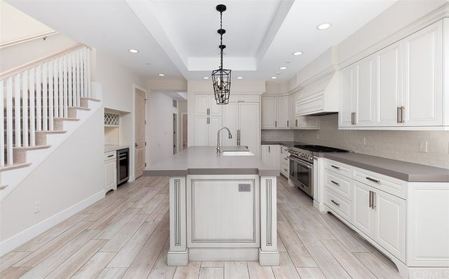 a large kitchen with stainless steel appliances granite countertop a lot of counter space and wooden floor