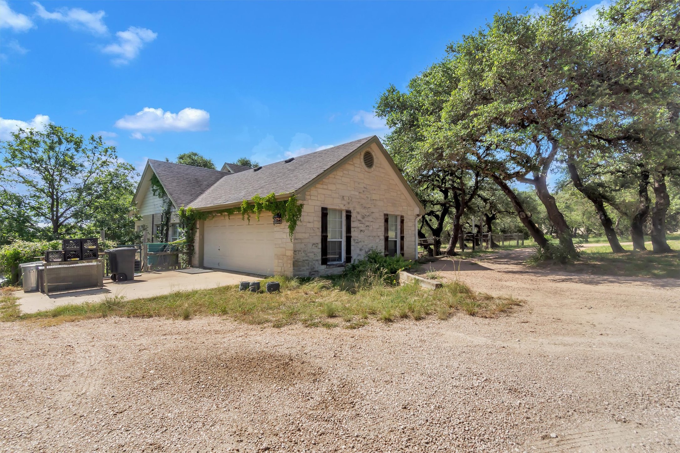 1120 Meadow Ridge Drive Austin, TX 78737 - Photo 28 of 40 A charming stone facade home nestled among mature trees offers serene outdoor living.