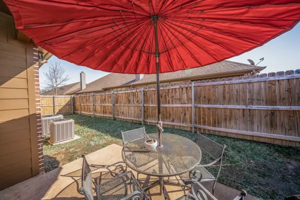 a patio with a table and chairs under an umbrella