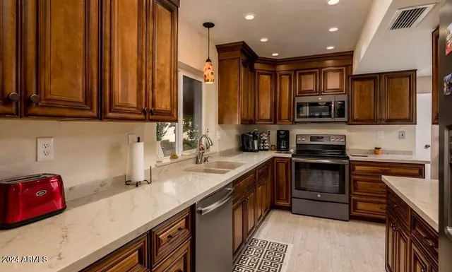 a kitchen with stainless steel appliances granite countertop a sink stove and cabinets
