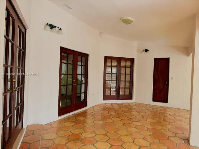 a view of an empty room with window and cabinet