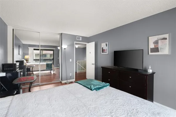 a bedroom with a bed and a flat screen tv