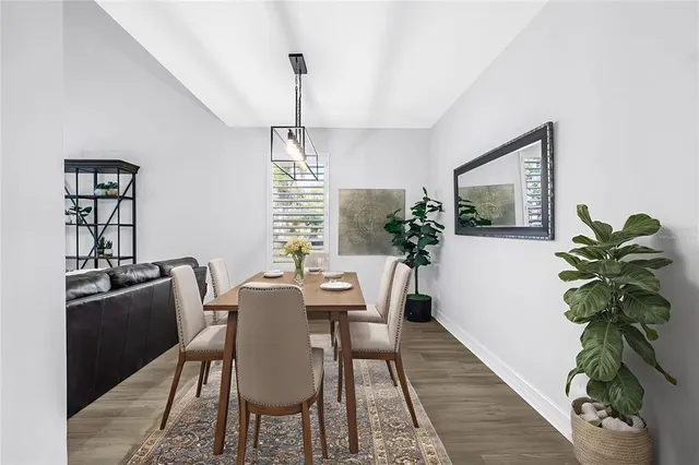 a dining room with furniture a chandelier and wooden floor