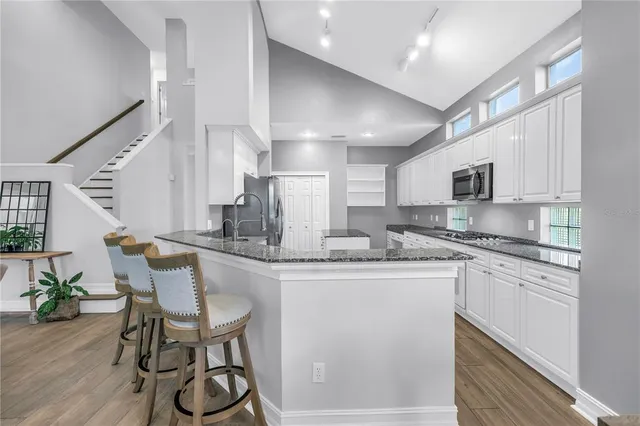 a kitchen with stainless steel appliances granite countertop a sink and cabinets
