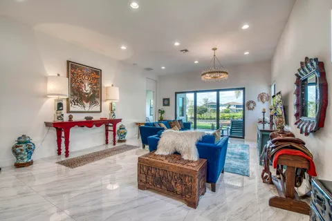 a living room with furniture a floor to ceiling window and a flat screen tv