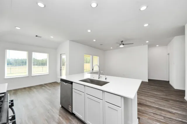 a kitchen with a sink and wooden floor