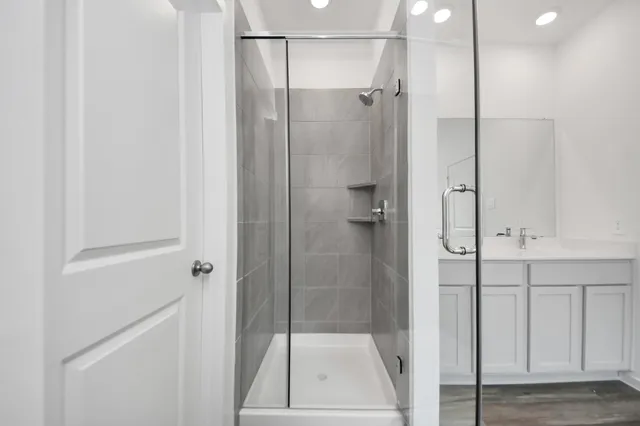 a bathroom with a glass shower door and a sink