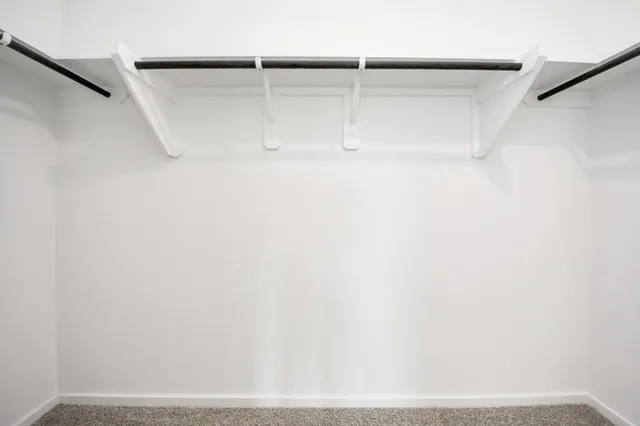 a view of an empty room with a chandelier fan