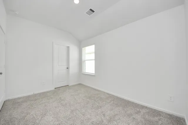 an empty room with window and ceiling fan