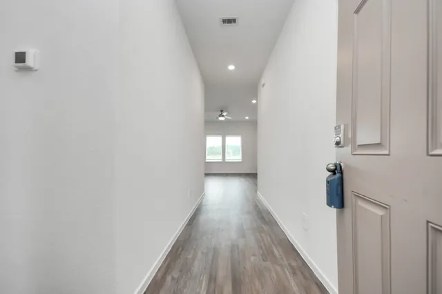 a view of a hallway with wooden floor and staircase