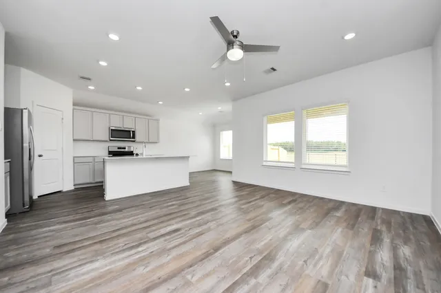 a view of an empty room with kitchen appliances and a window