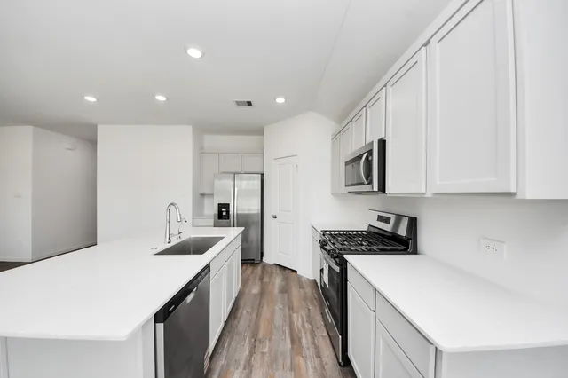 a kitchen with a sink a stove and cabinets