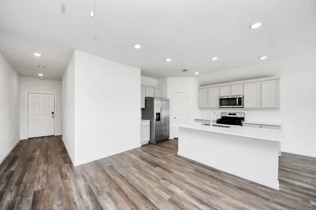 a kitchen with stainless steel appliances refrigerator sink and microwave