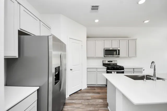 a kitchen with stainless steel appliances a refrigerator stove microwave and sink