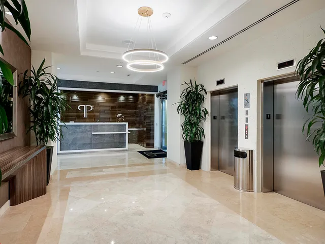 an empty room with potted plants and a fireplace