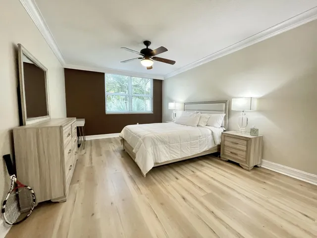 a bedroom with a bed and a flat tv screen on dresser