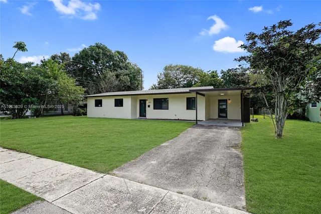 a front view of house with a garden