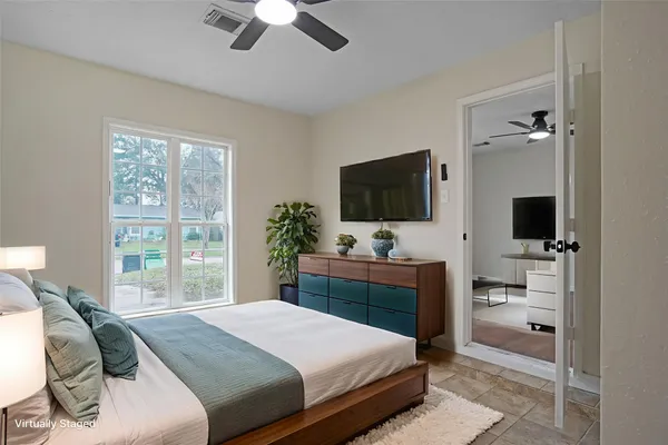 a bedroom with a bed and a flat screen tv
