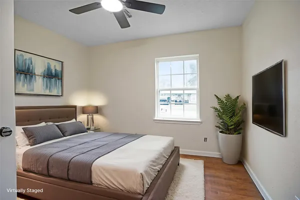a bedroom with bed potted plant and a window