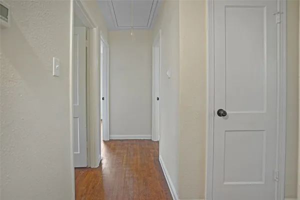 a view of a hallway with wooden floor