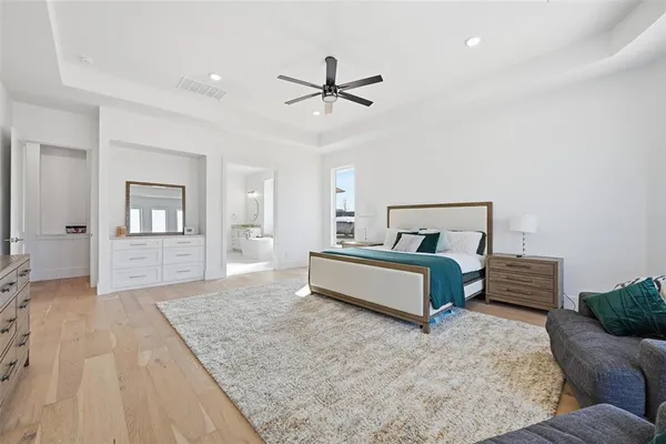 a bedroom with a large bed and a chandelier