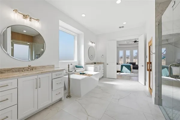 a spacious bathroom with a toilet a double vanity sink and mirror
