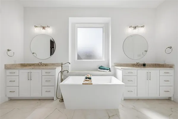 a bathroom with a double vanity sink mirror and bathtub