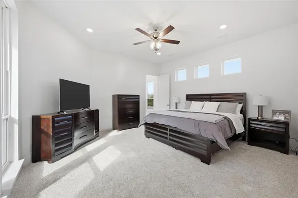 a spacious bedroom with a bed and a flat screen tv