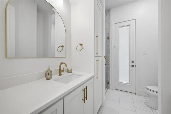 a bathroom with a sink a toilet and a mirror